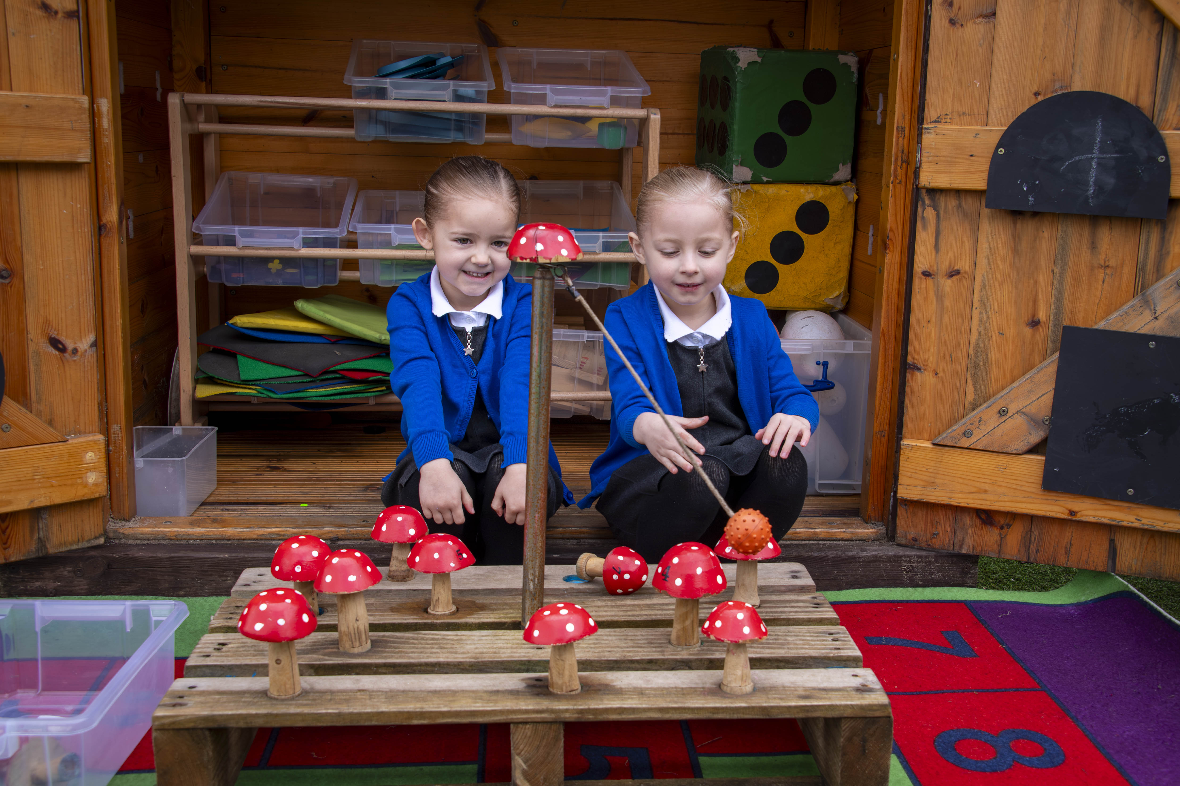 Pupils Lexi and Myla Locking enjoy the toadstool counting game, handmade by the father of a teacher at the school.